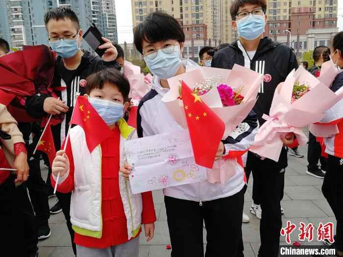 图为3月21日张静静跟随医疗队从黄冈返程时,手里拿着当地小朋友送给她的一幅画。山东大学齐鲁医院供图 援鄂护师张静静去世 国家卫健委:人民会感激和怀念她